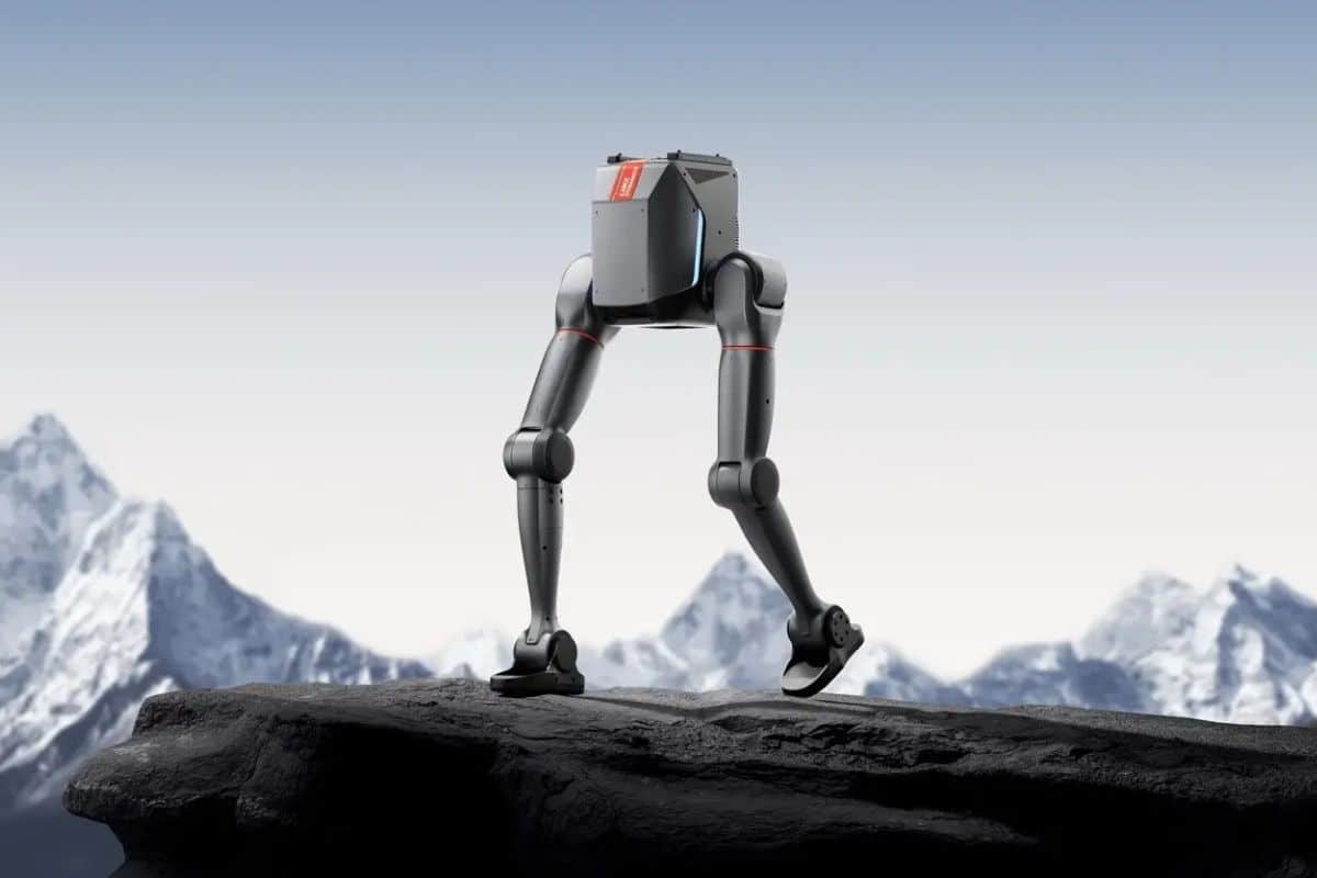 Robot bipède marchant sur une montagne enneigée.