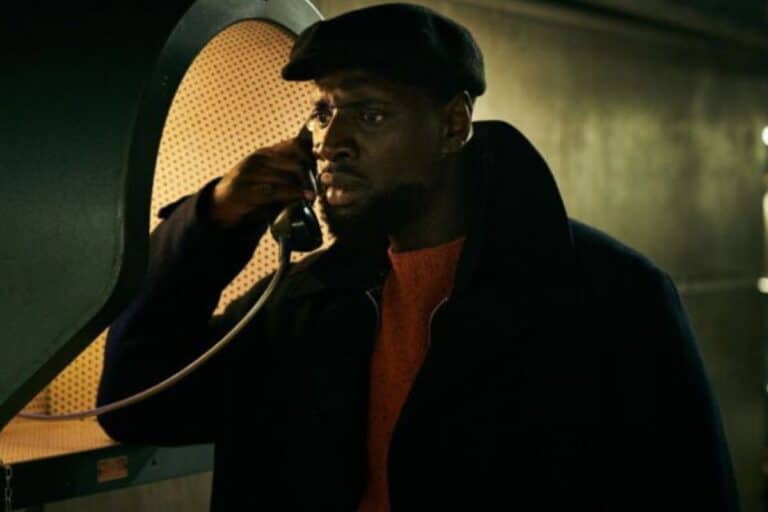 Homme parlant dans une cabine téléphonique rétro.