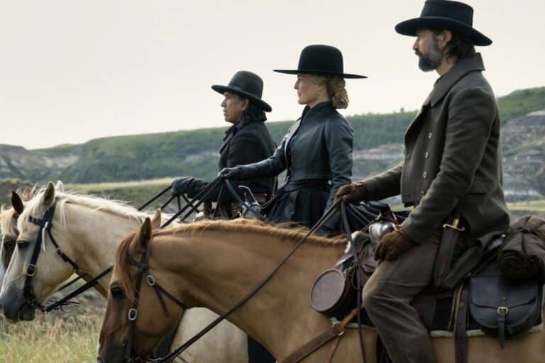 Trois cavaliers portant des chapeaux en plein air.