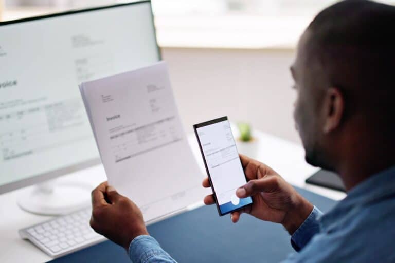 Homme scannant un document avec son smartphone.