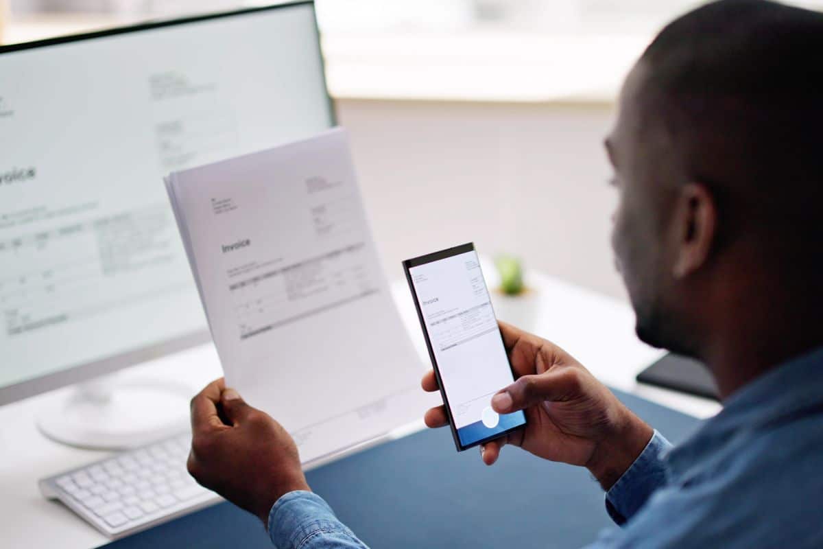 Homme scannant un document avec son smartphone.