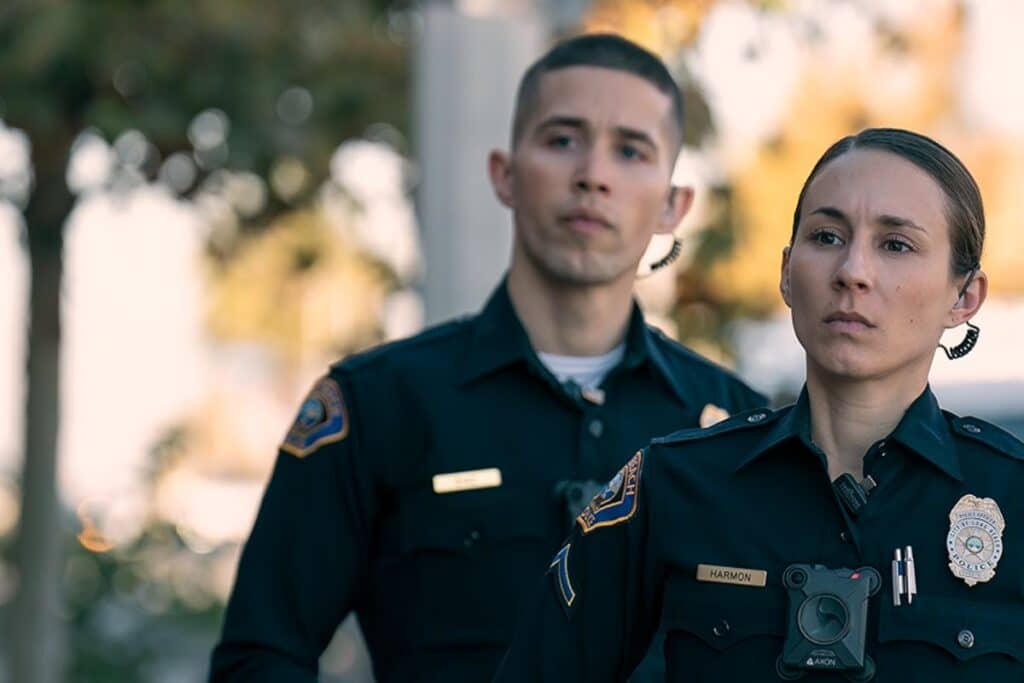 Deux policiers en uniforme regardent au loin.