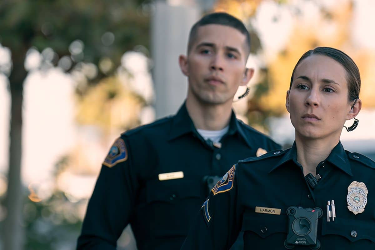 Deux policiers en uniforme regardent au loin.