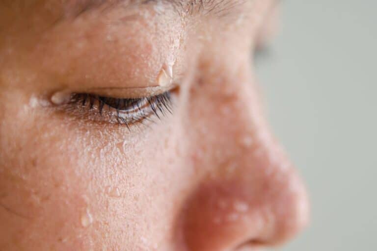 Visage proche avec gouttes de sueur.