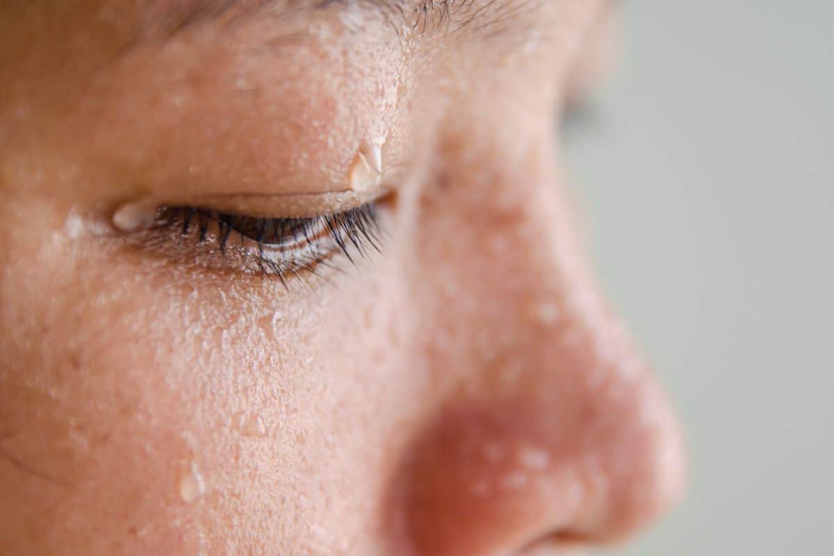 Visage proche avec gouttes de sueur.