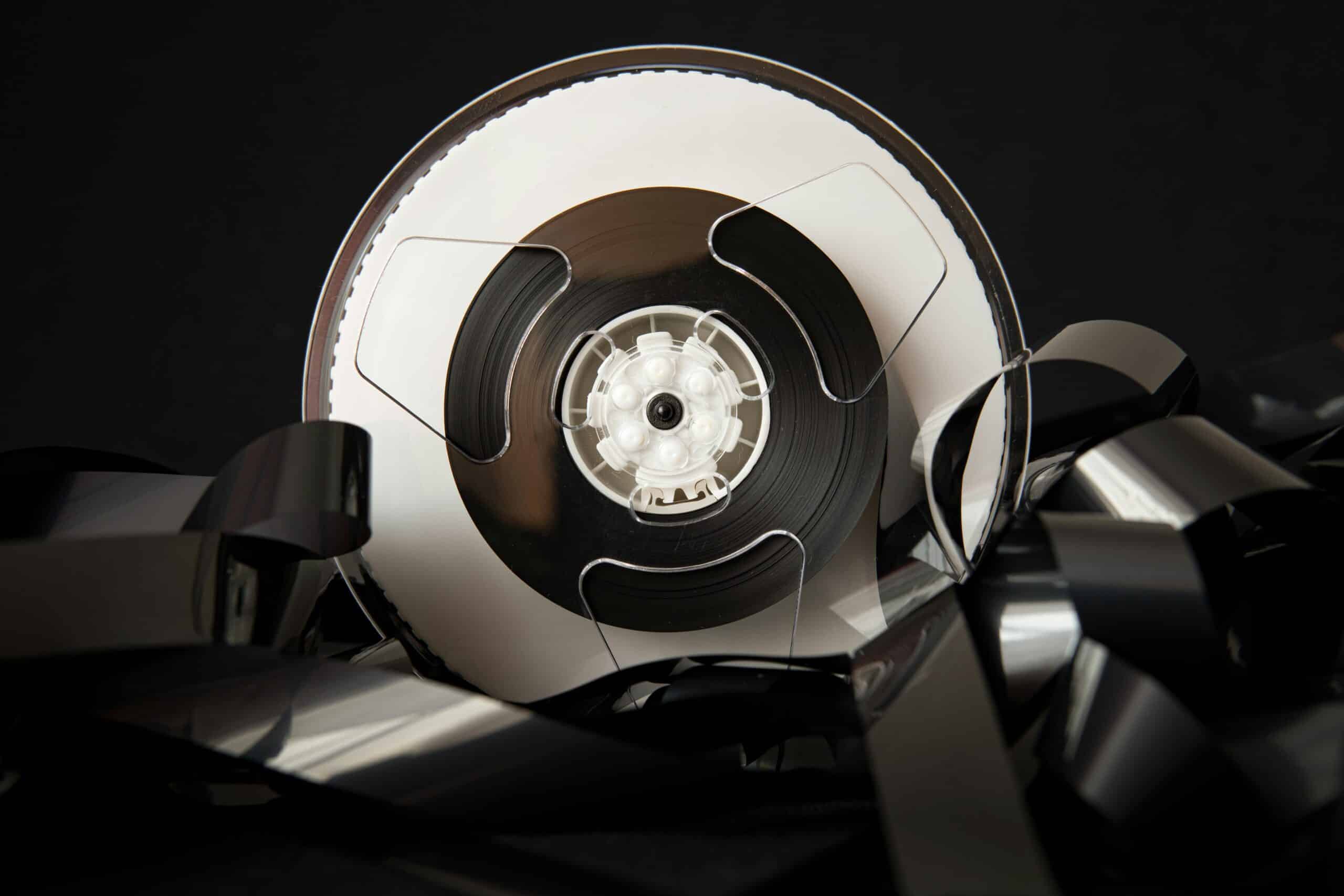 Bobine de bande magnétique déroulée en noir et blanc.