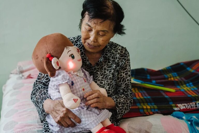 Femme âgée tenant une poupée lumineuse.