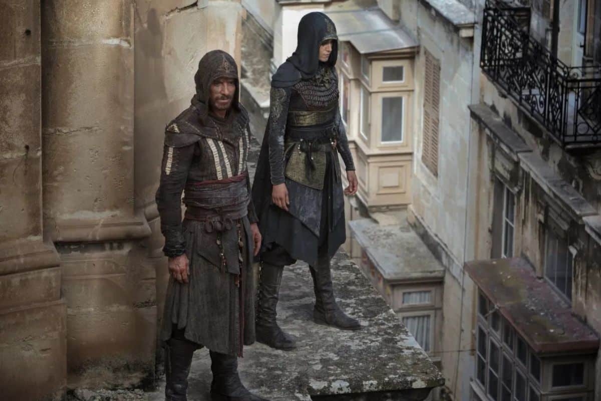 Deux personnages en vêtements médiévaux sur un toit.