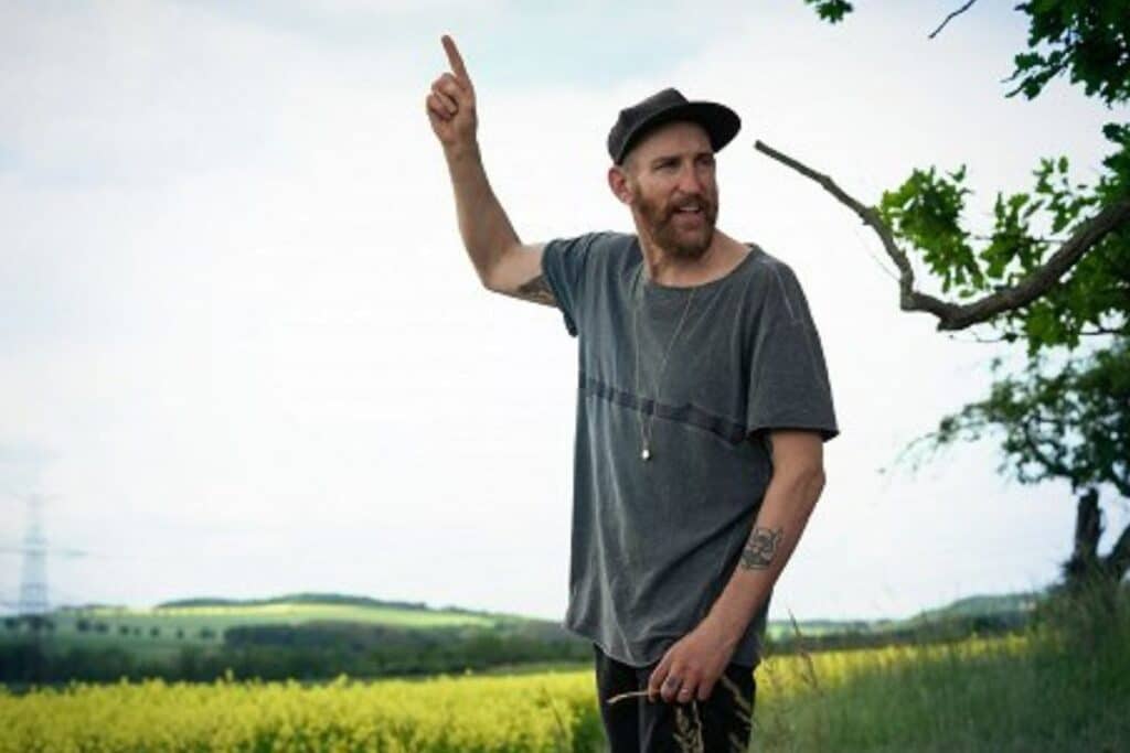 Homme pointant vers le ciel dans la campagne.