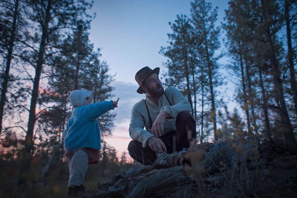 Enfant et adulte explorant la forêt au crépuscule.
