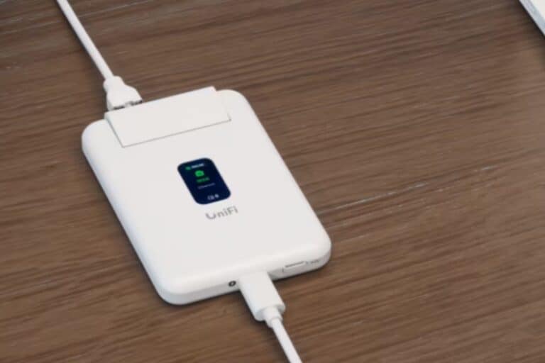 Routeur blanc UniFi sur bureau en bois.