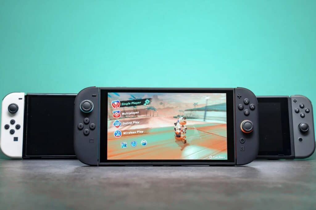 Trois consoles de jeux avec écran allumé.