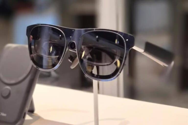 Lunettes connectées modernes sur présentoir blanc.