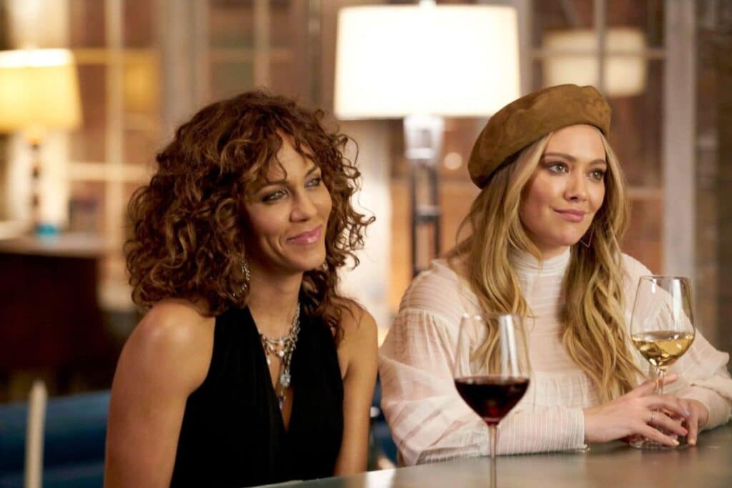 Deux femmes souriantes avec des verres de vin.