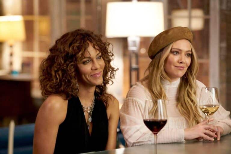 Deux femmes souriantes avec des verres de vin.