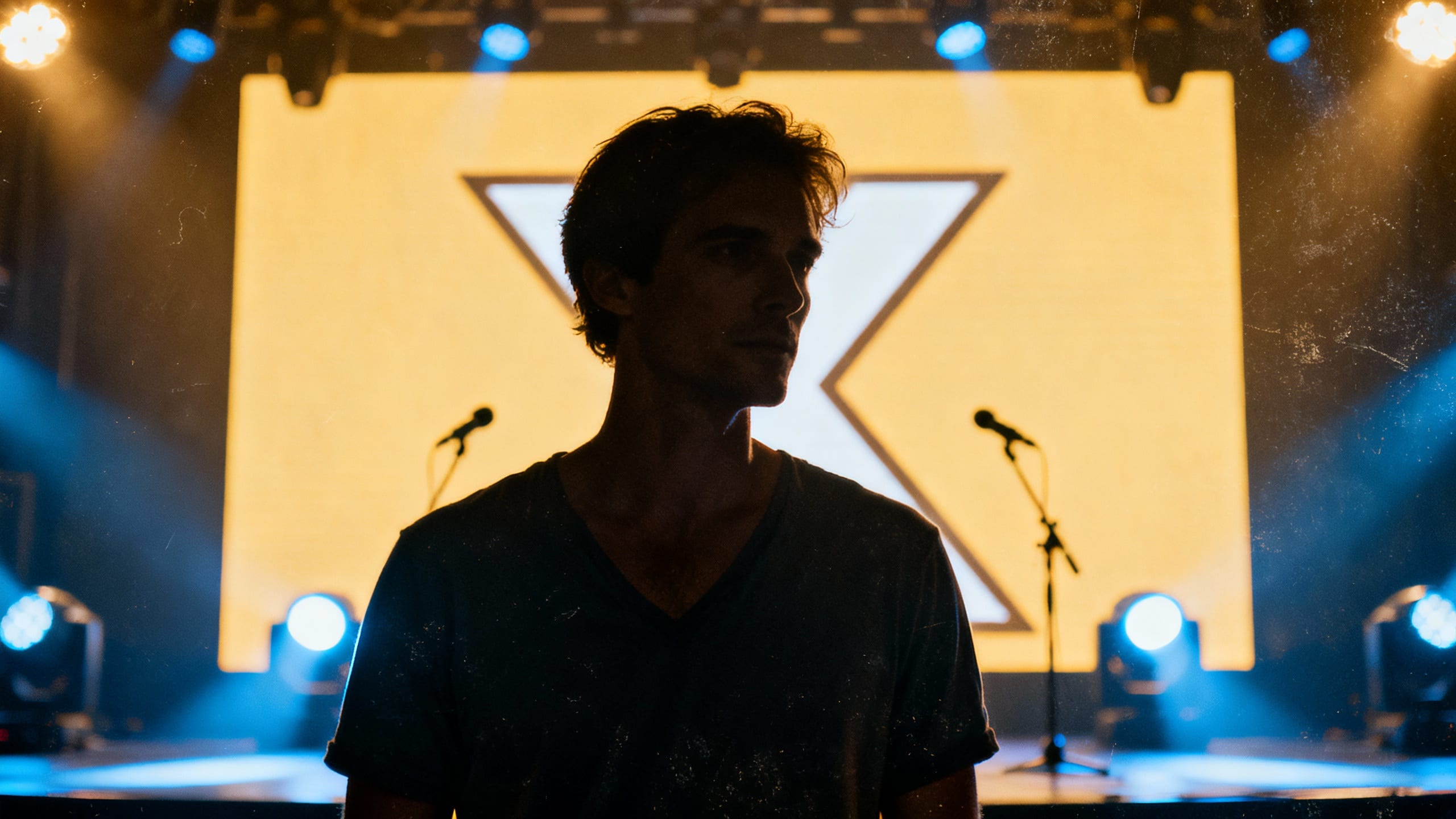 Silhouette d'homme sur scène avec éclairage lumineux.