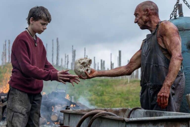 Deux personnes échangent un crâne humain dehors.