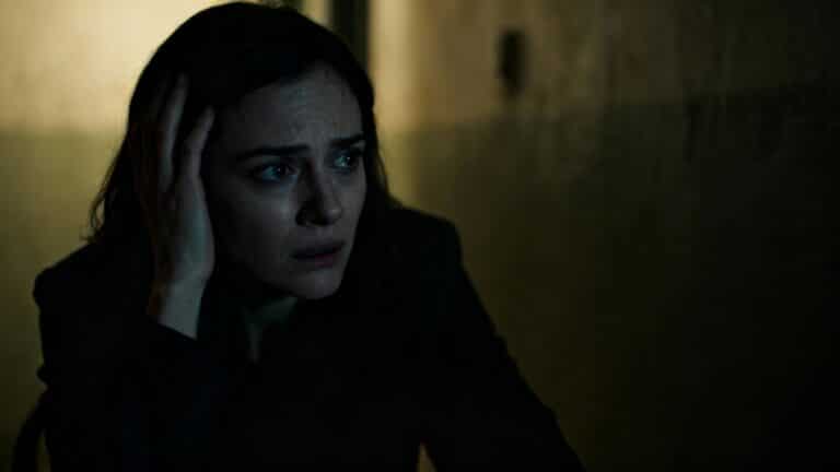 Personne apeurée dans un couloir sombre.