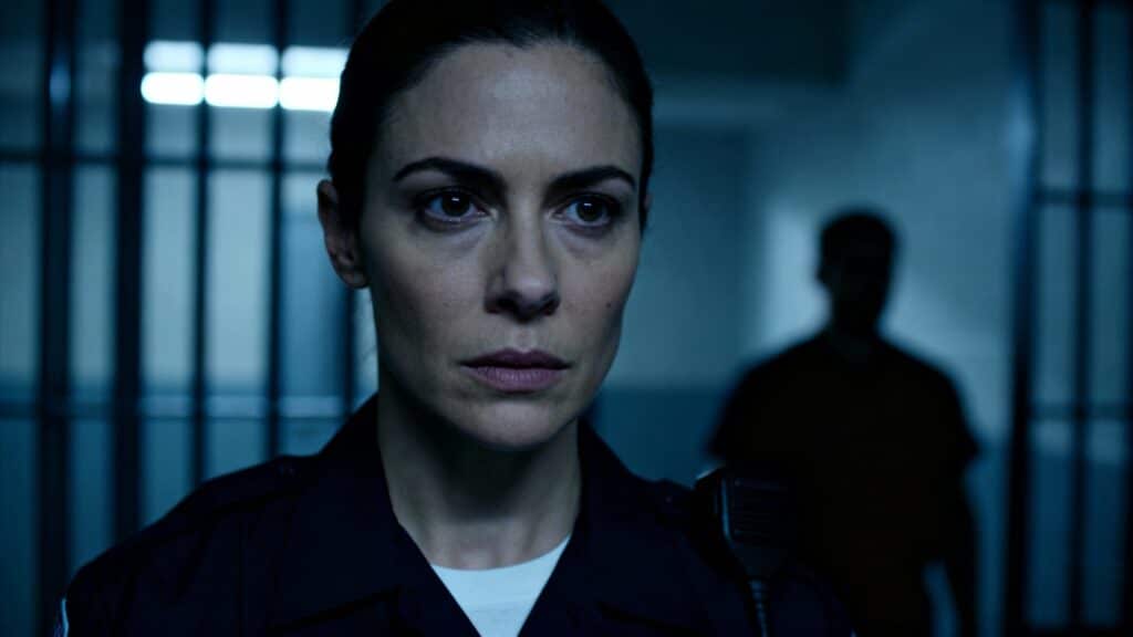 Femme policière devant les barreaux.