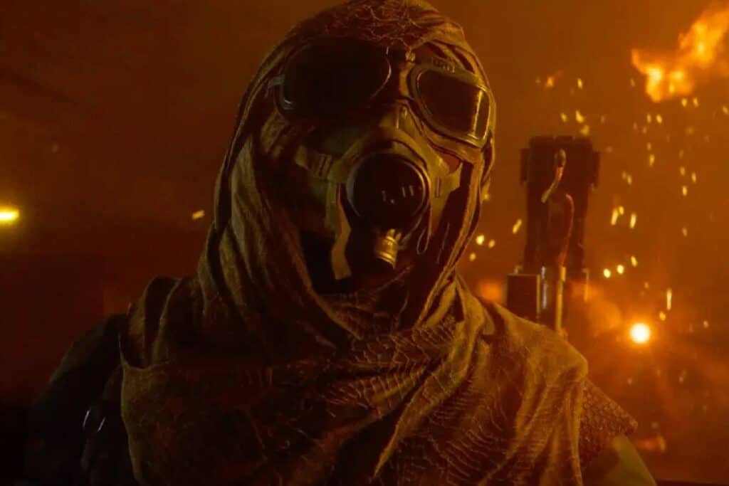 Personne masquée dans un environnement enflammé.