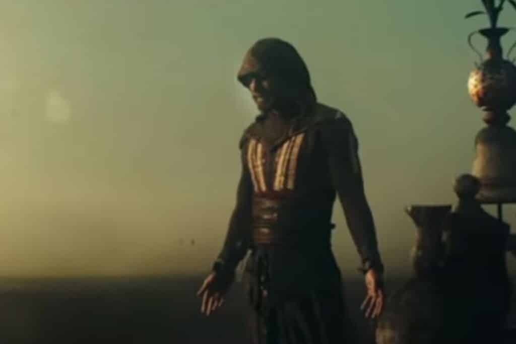 Personne en capuche face à un décor désertique.