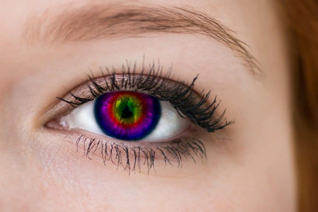 Œil avec lentille de contact arc-en-ciel colorée.