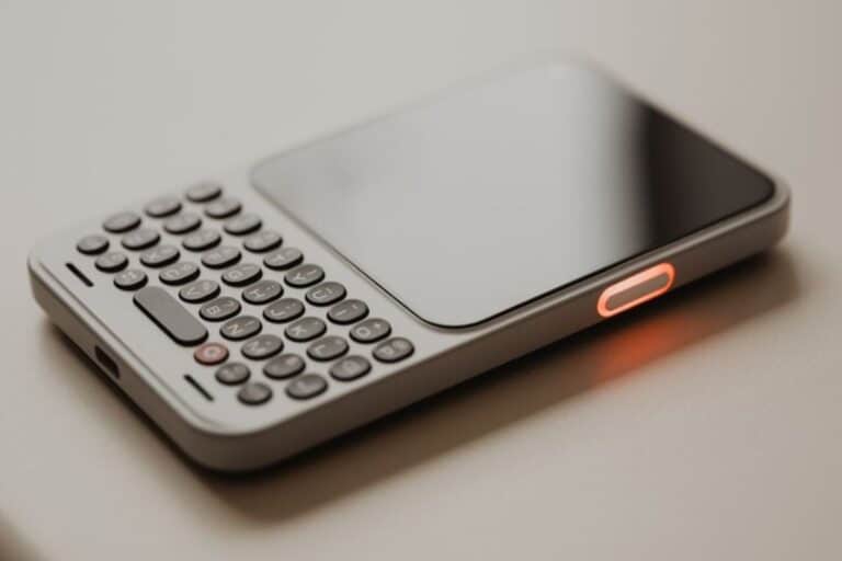 Téléphone avec clavier, écran et lumière rouge.
