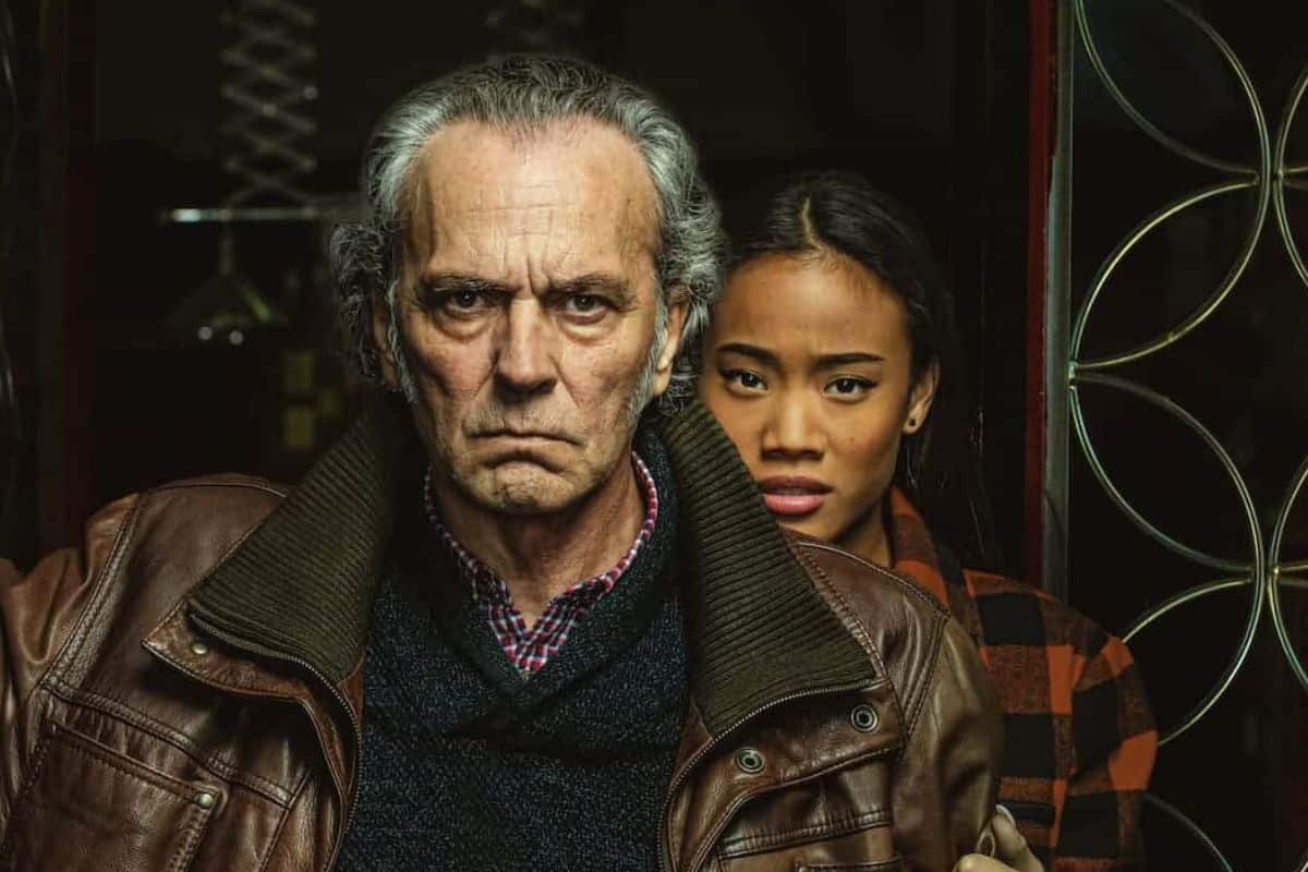 Homme et femme sérieux devant une porte.