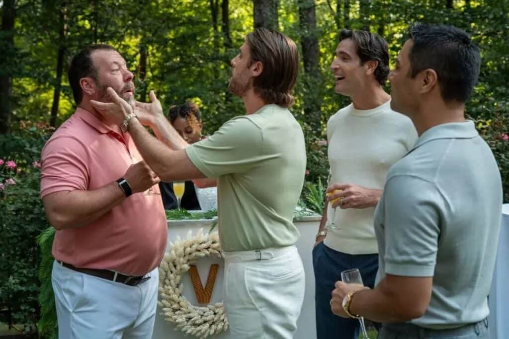 Groupe d'hommes discutant lors d'un événement en extérieur.