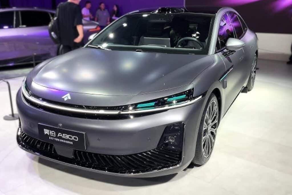 Voiture électrique grise exposée dans un salon automobile.