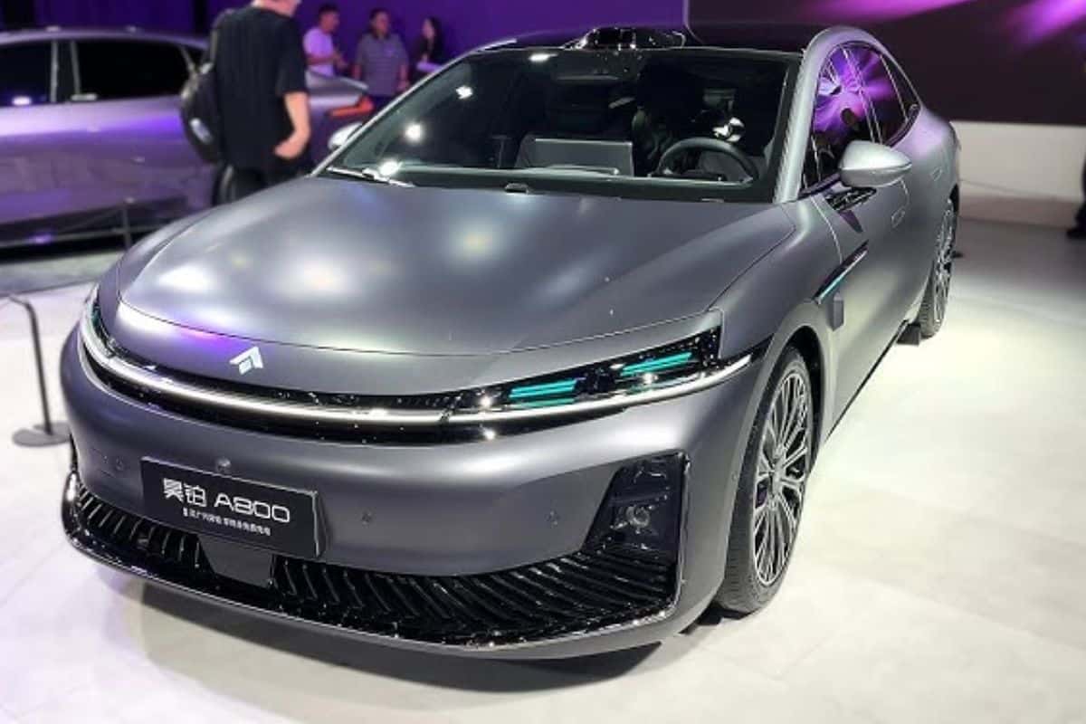 Voiture électrique grise exposée dans un salon automobile.