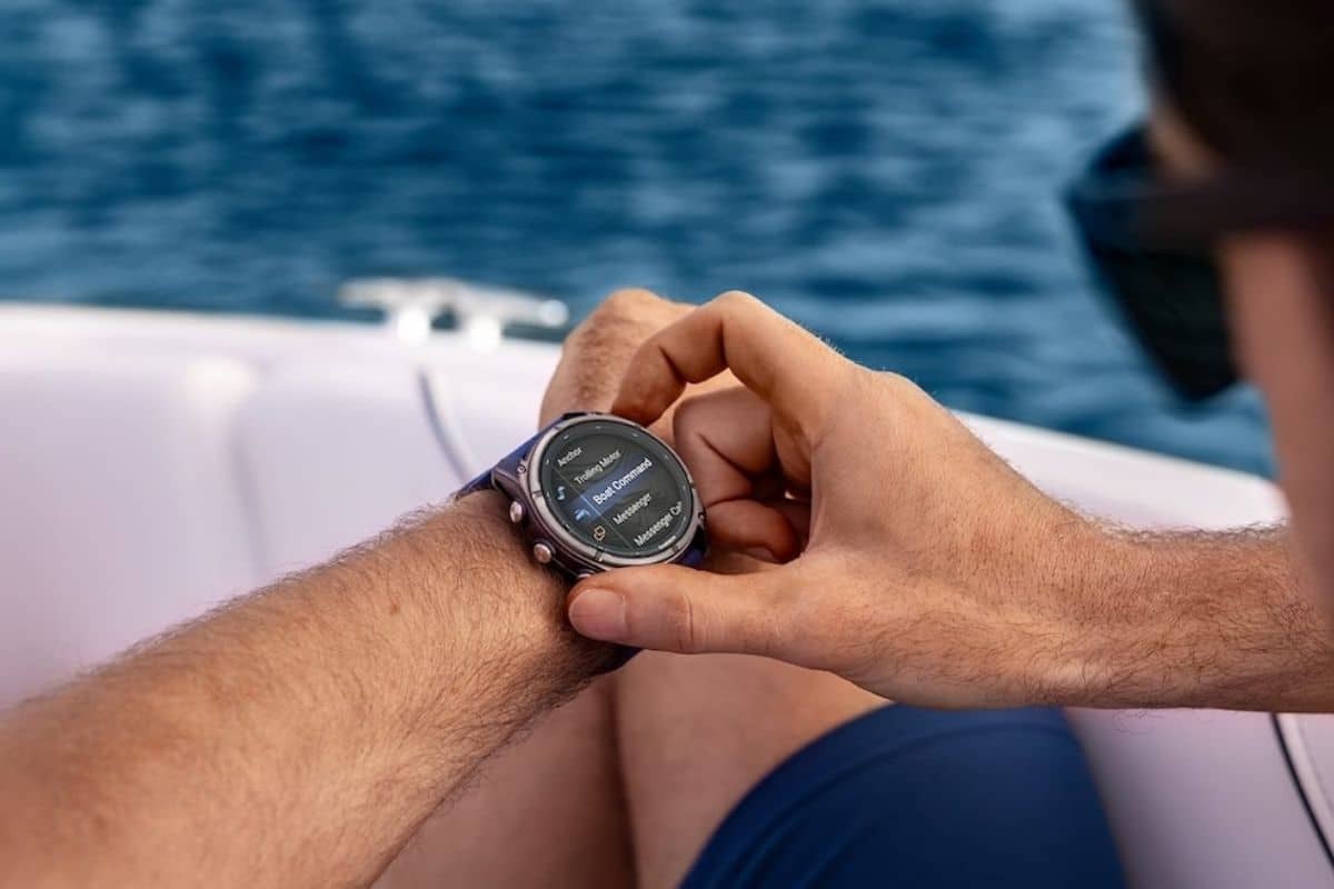 Homme utilisant une montre connectée en bateau.