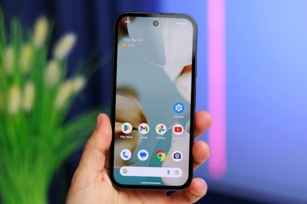 Smartphone tenu en main, applications affichées à l'écran.