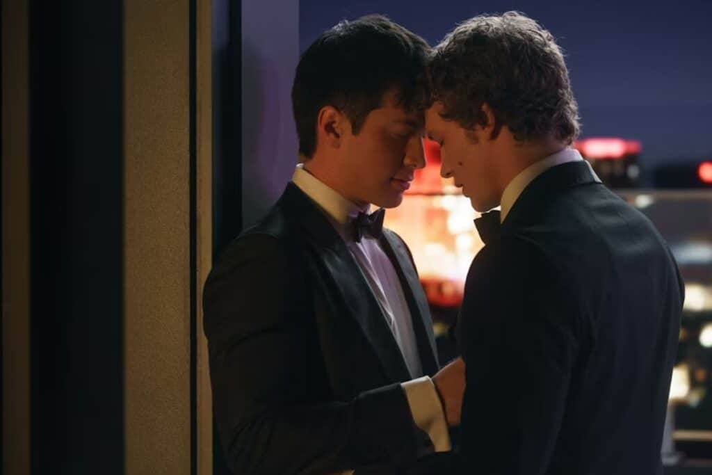 Deux hommes en costumes se rapprochent tendrement.