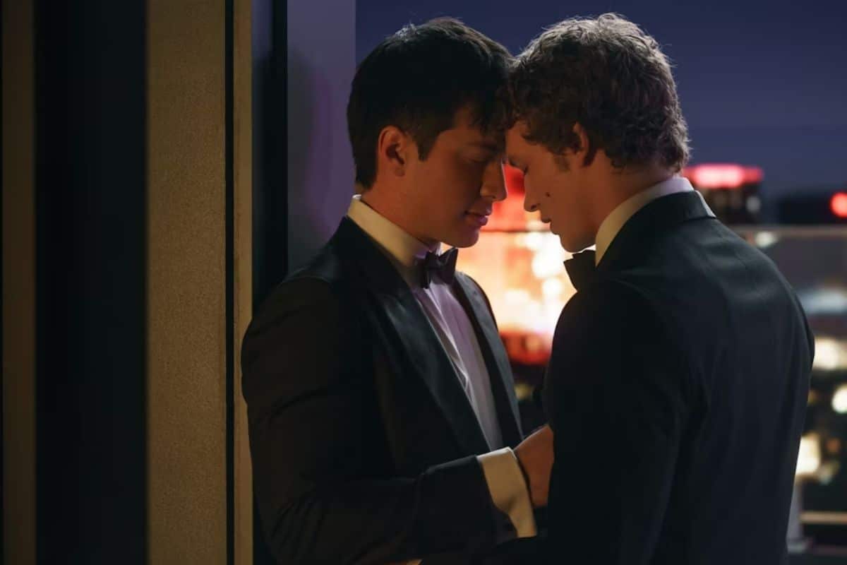 Deux hommes en costumes se rapprochent tendrement.