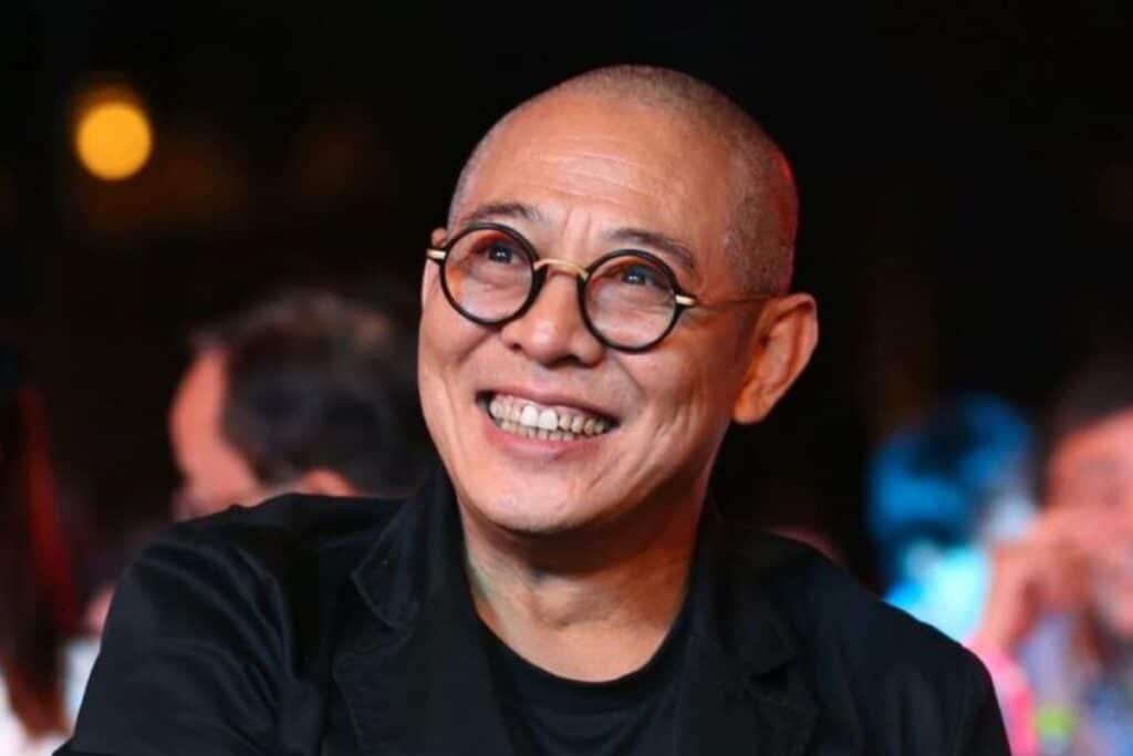 Personne souriante avec lunettes rondes.