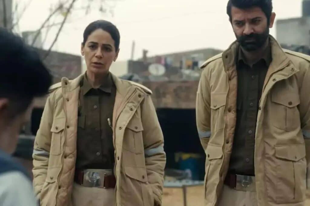 Deux policiers discutent dehors avec une personne.