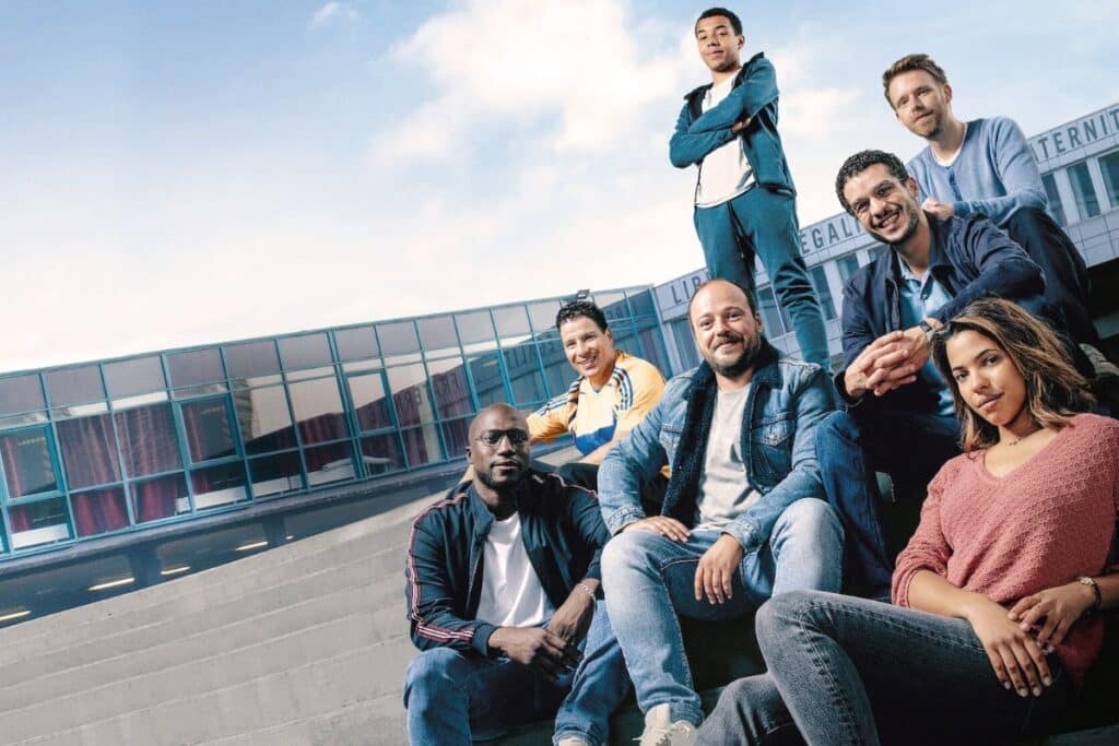 Personnes assises devant un bâtiment moderne.