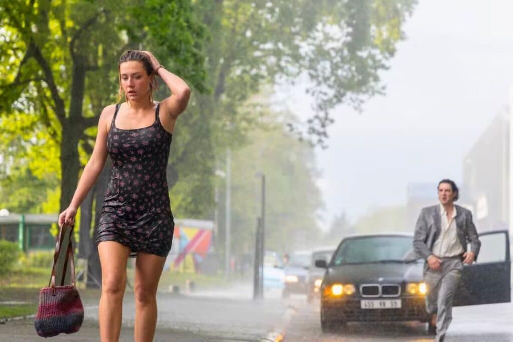 Femme et homme sous la pluie dans la rue.