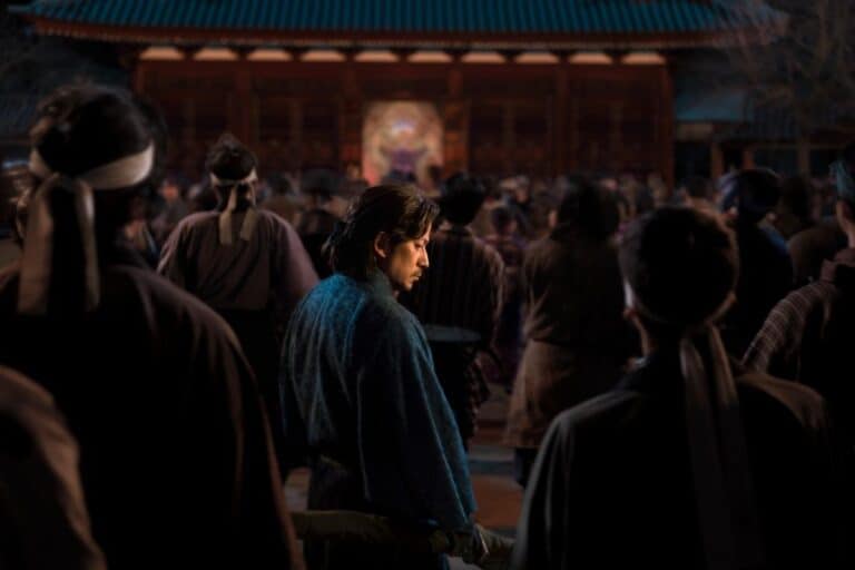 Homme en kimono bleu dans une foule.
