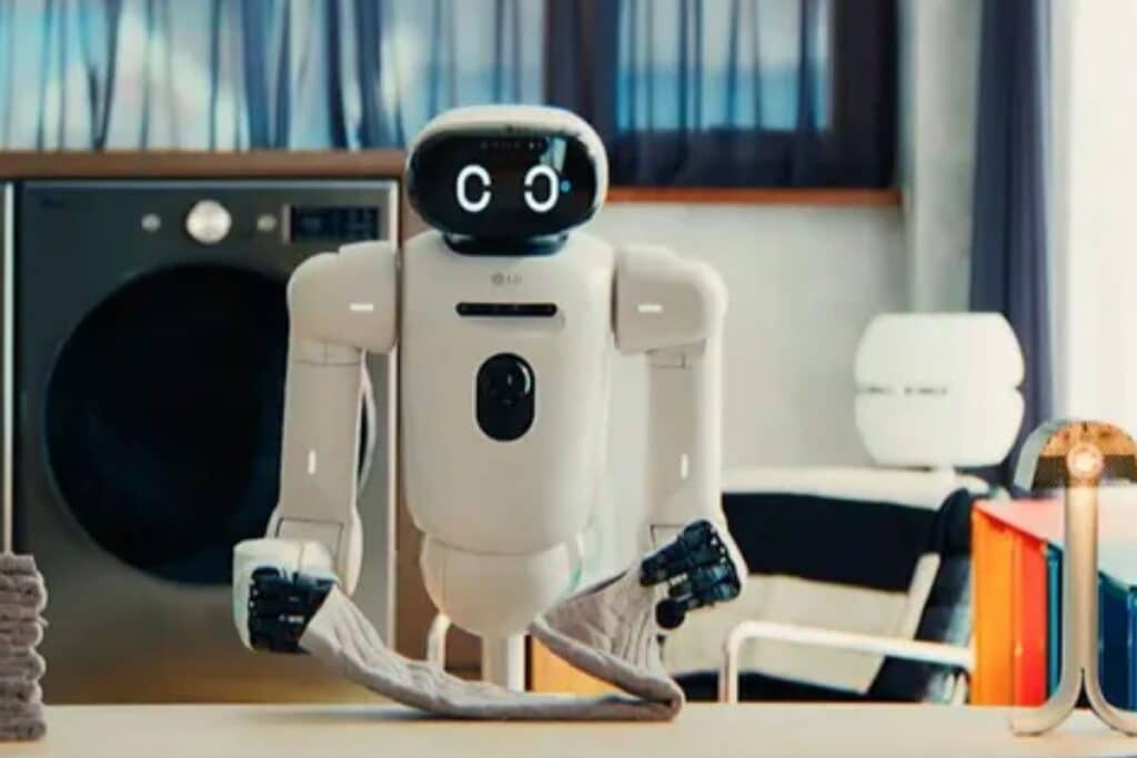 Robot pliant une serviette devant une machine à laver.