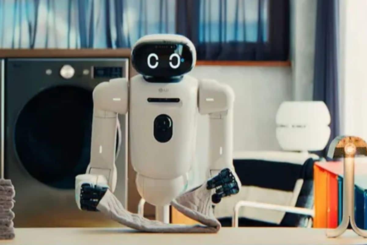 Robot pliant une serviette devant une machine à laver.