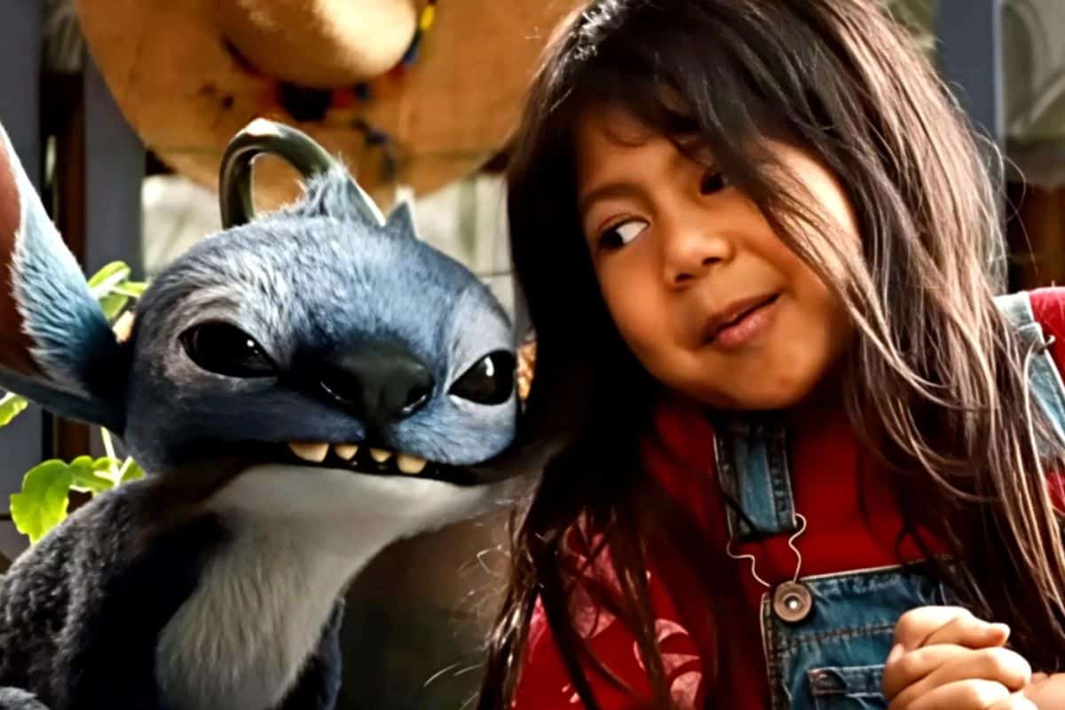 Enfant sourit à personnage bleu, oreilles pointues.