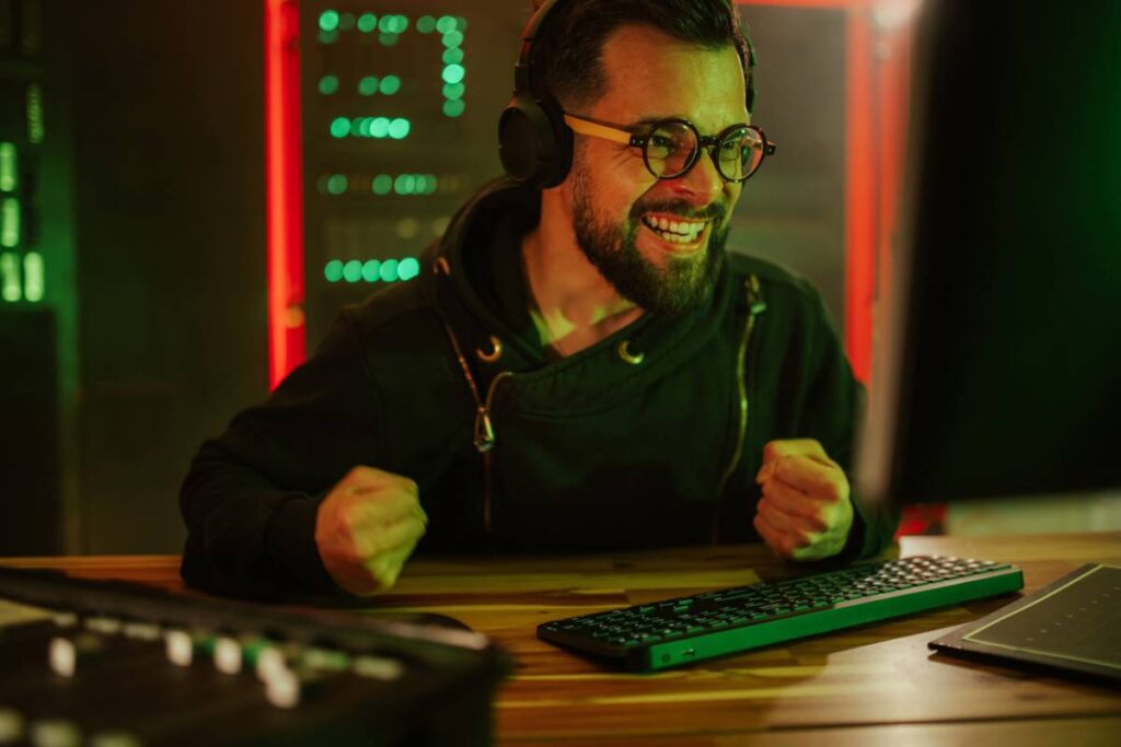 Homme souriant avec casque devant ordinateur