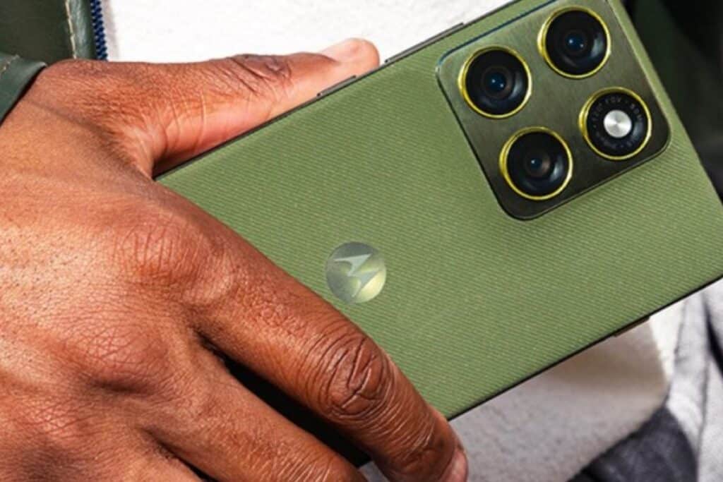 Smartphone vert avec quadri-caméra, tenu par une main.