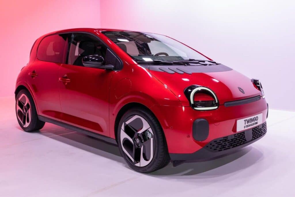 Voiture rouge électrique exposée sur fond rose.