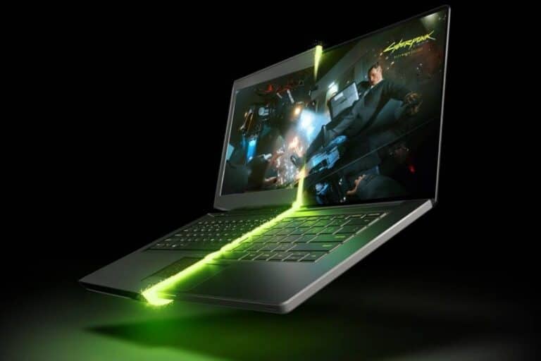 Ordinateur portable avec écran lumineux et fond noir.