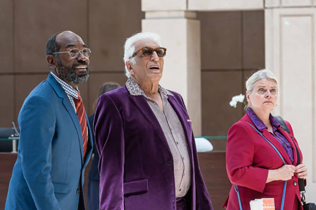 Trois personnes regardant attentivement en costume coloré.