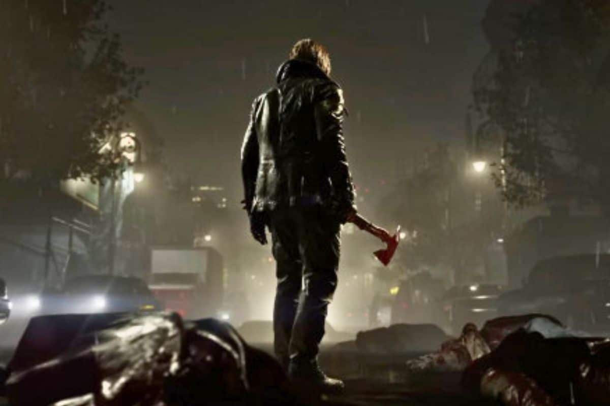 Homme tenant une hache, vue de dos, la nuit.