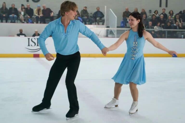 Couple patinant sur la glace en costumes bleus.